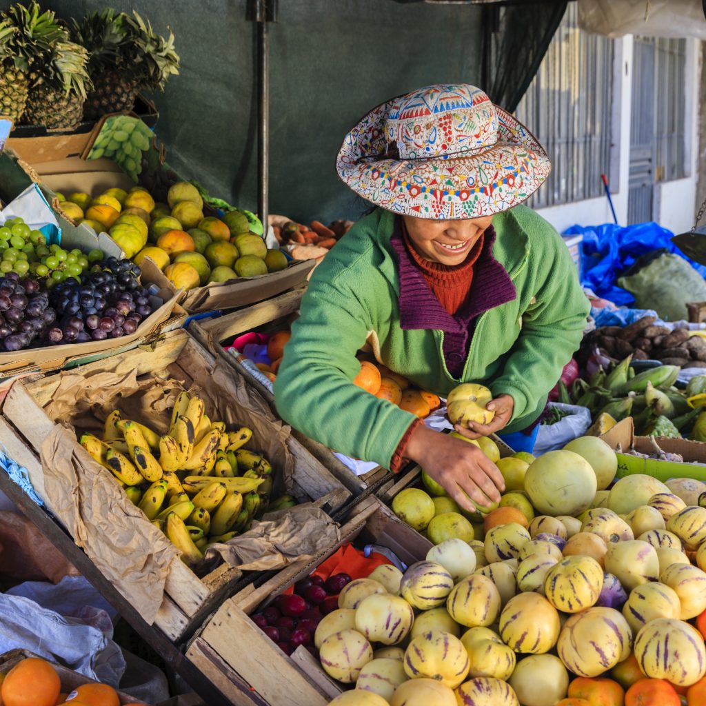 Indigenous Peruvian woman selling fruits in a market